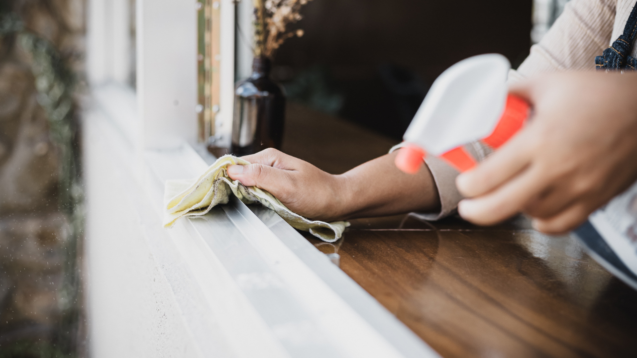 Image of a cleaner wiping down a windowsill